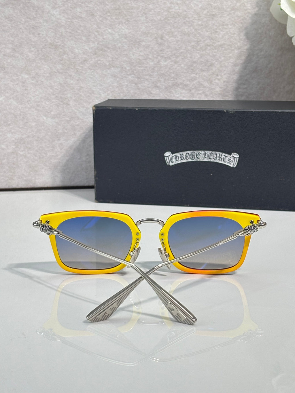 Blue-tinted square eyeglasses with bright yellow frame and silver metal temple hinges