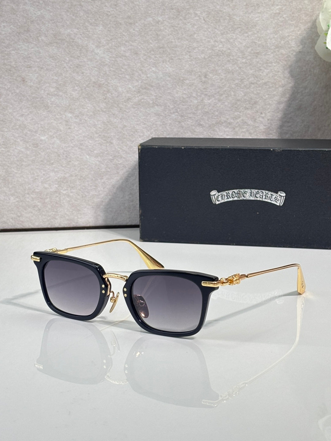 Smoke-tinted square eyeglasses with gold-tone frame and dark lenses