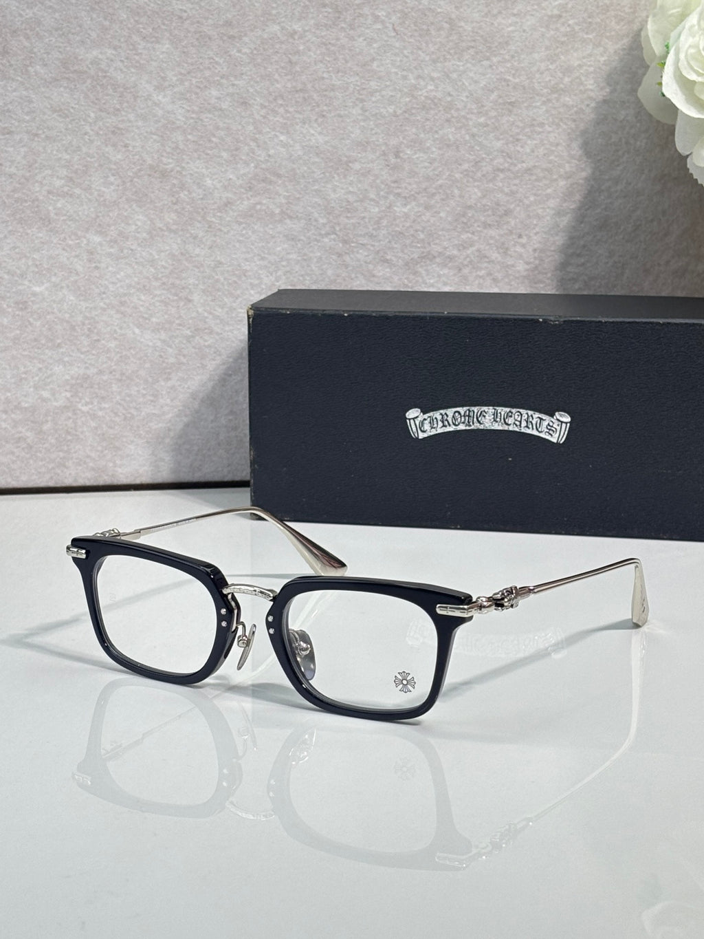 Chrome glasses with black rectangular frames and clear lenses, side view