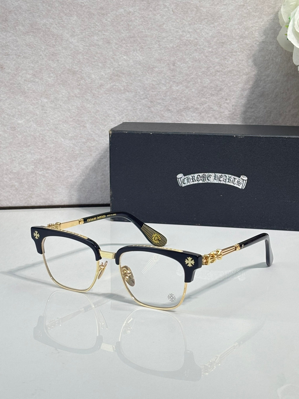 Eyeglasses with dark frame, clear lenses, gold temple arms with star pattern