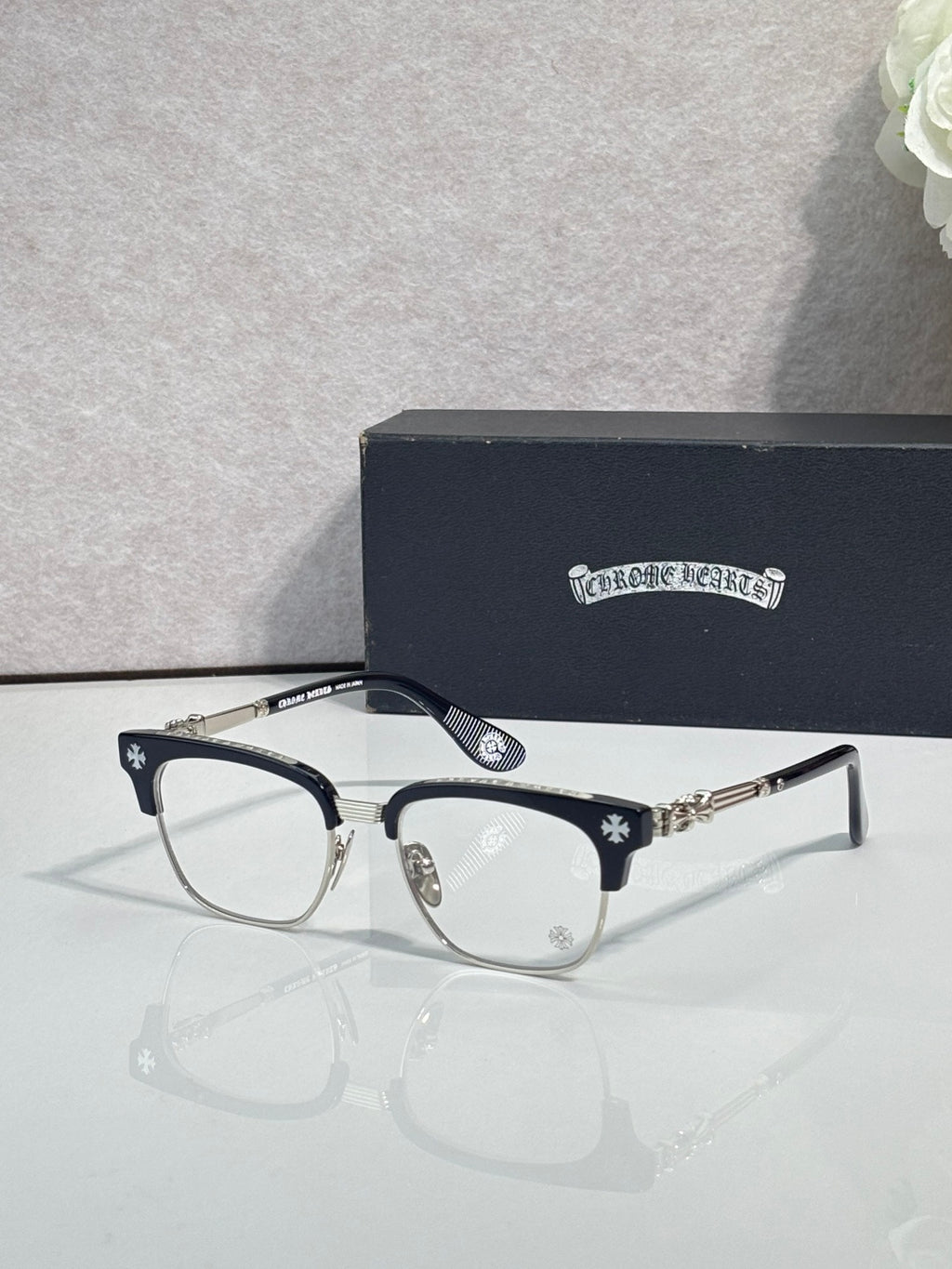 Eyeglasses with dark frame, clear lenses, gold temple arms with star pattern
