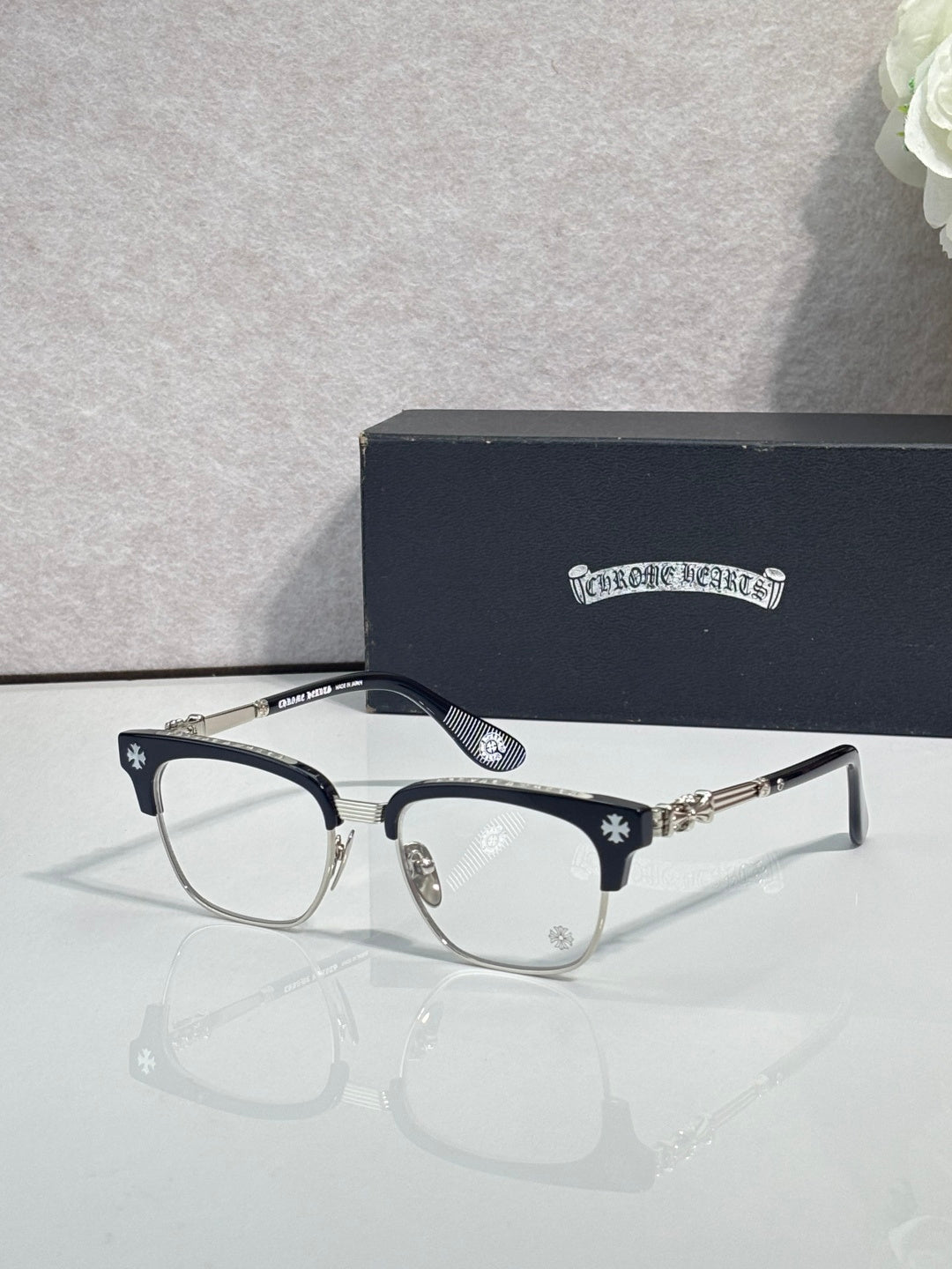 Eyeglasses with dark frame, clear lenses, gold temple arms with star pattern