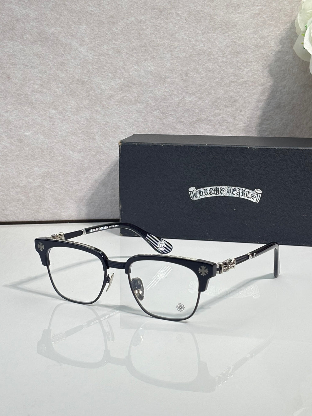 Eyeglasses with dark blue frame, clear lenses, gold hinge and temple accents
