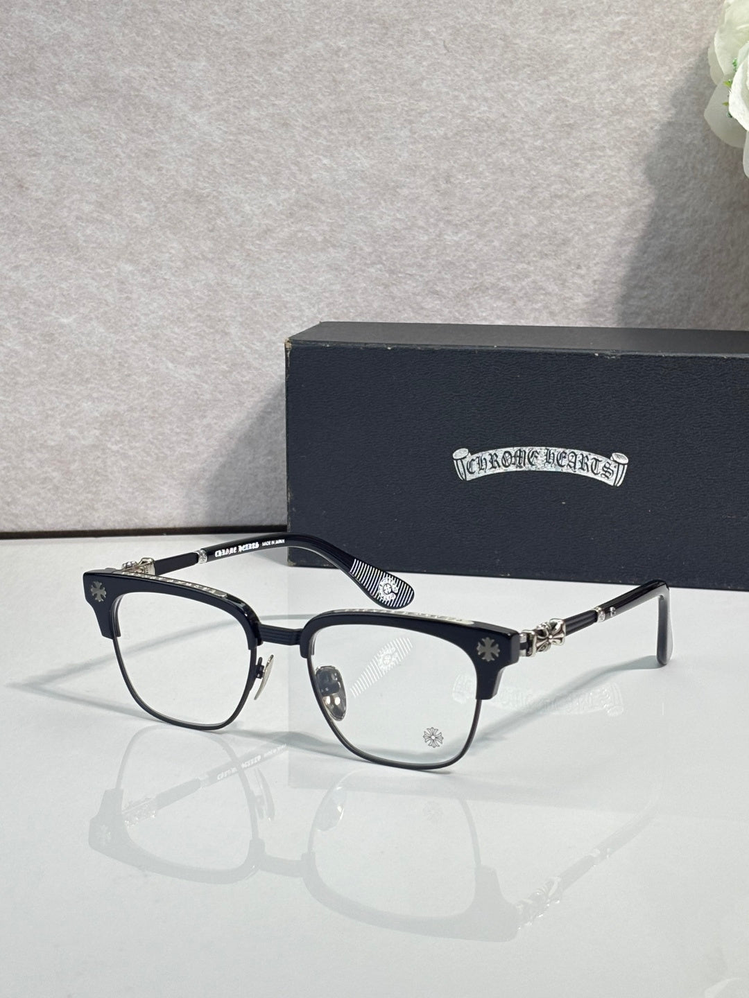 Eyeglasses with dark blue frame, clear lenses, gold hinge and temple accents