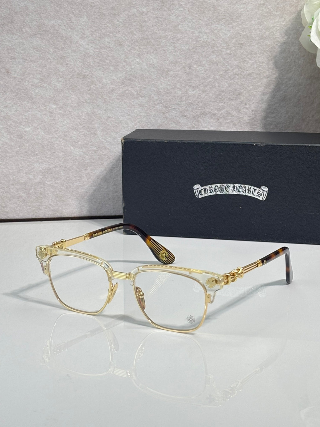Eyeglasses with light tortoise frame, clear lenses, gold arms with ornate pattern