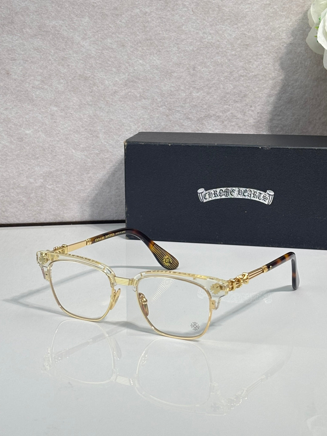 Eyeglasses with light tortoise frame, clear lenses, gold arms with ornate pattern
