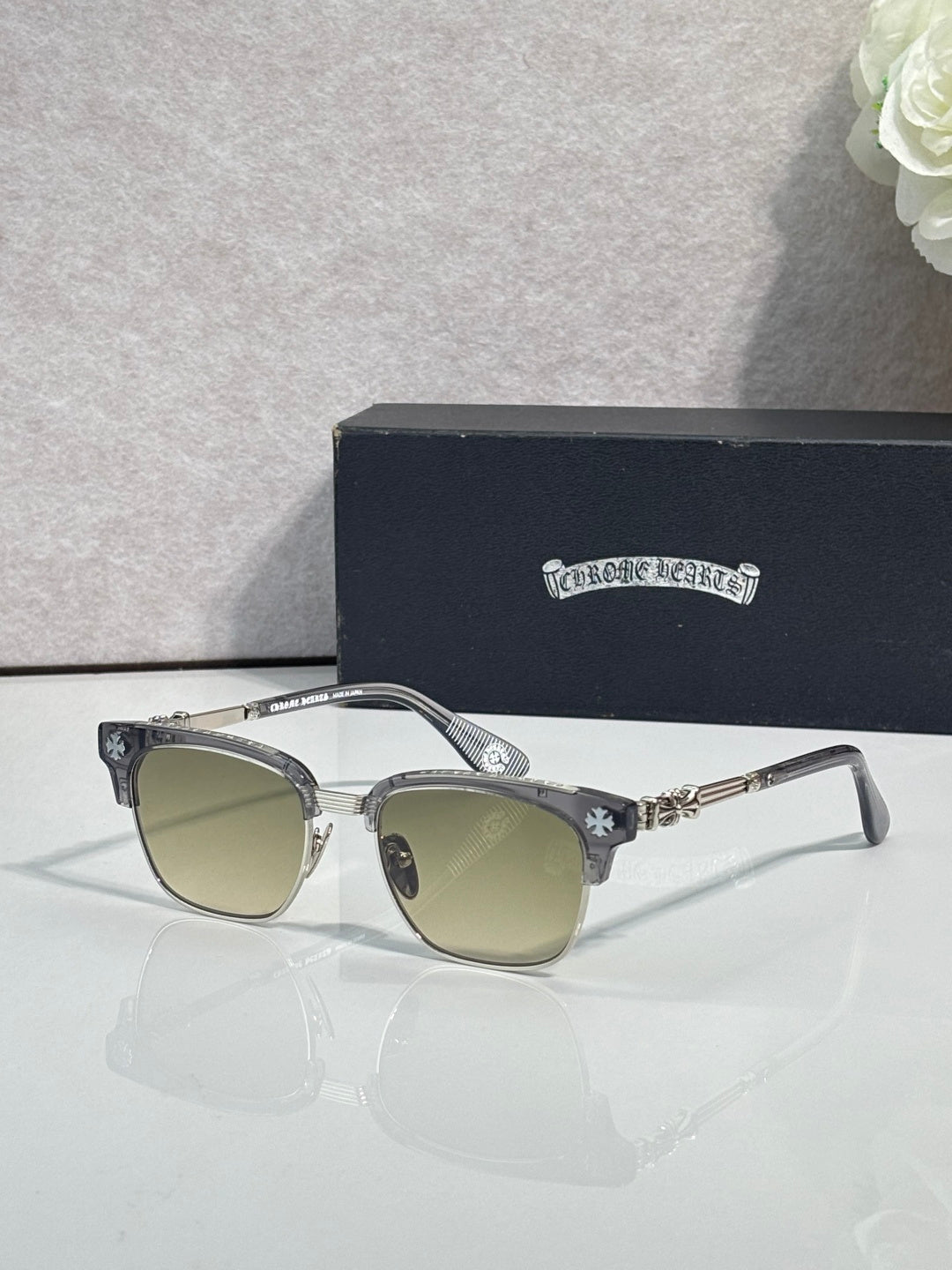 Cat-eye glasses with silver frame, gold arms, and light-tinted lenses