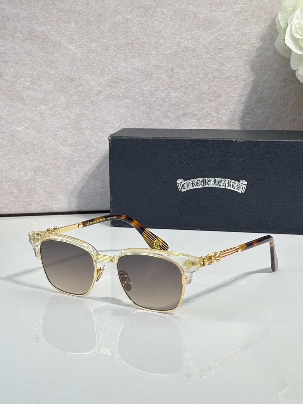 Cat-eye glasses with gold-tortoise frame, gold arms, and light-tinted lenses