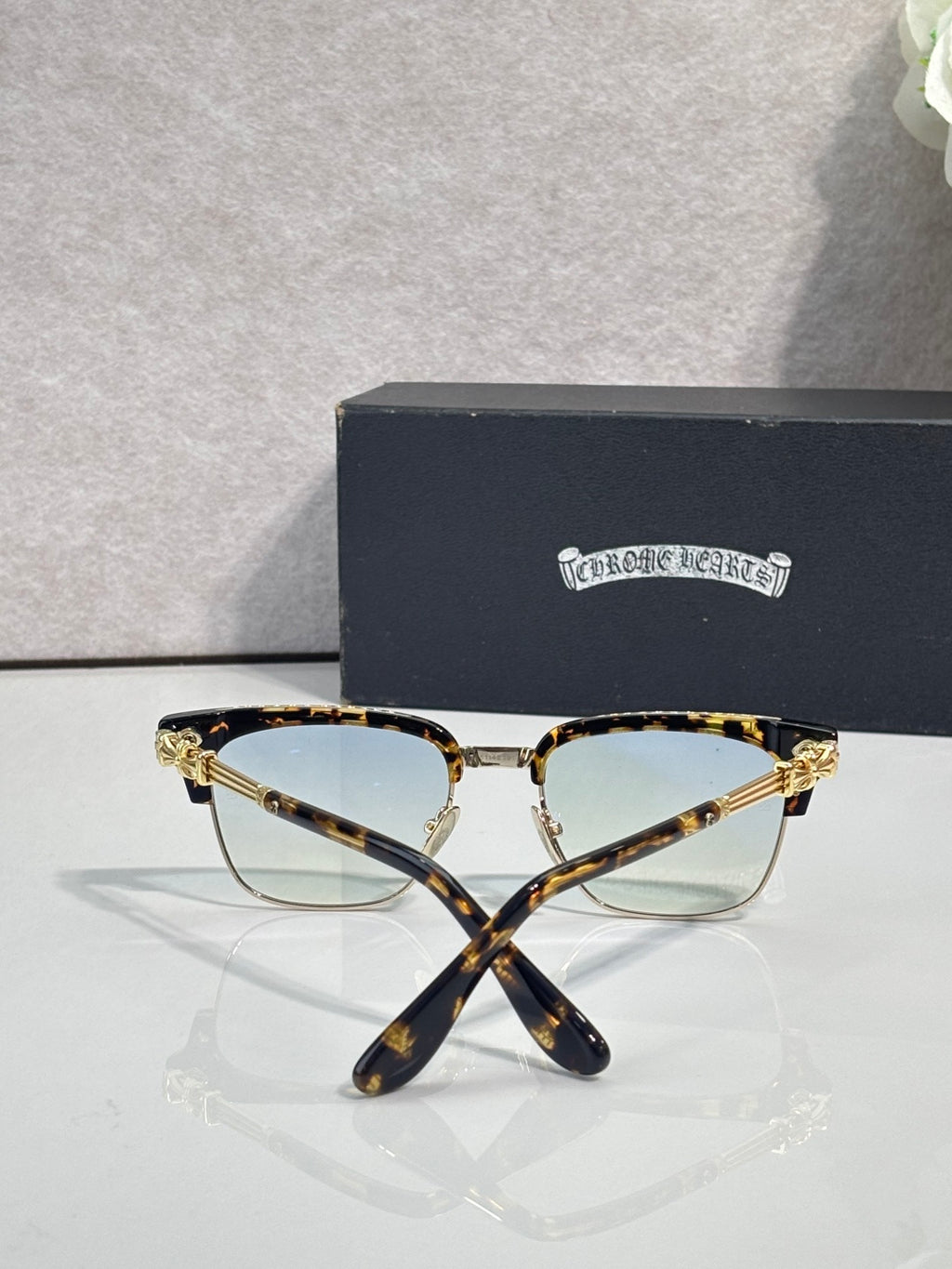 Cat-eye glasses with tortoise frame, gold arms, and clear lenses