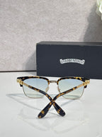 Cat-eye glasses with tortoise frame, gold arms, and clear lenses