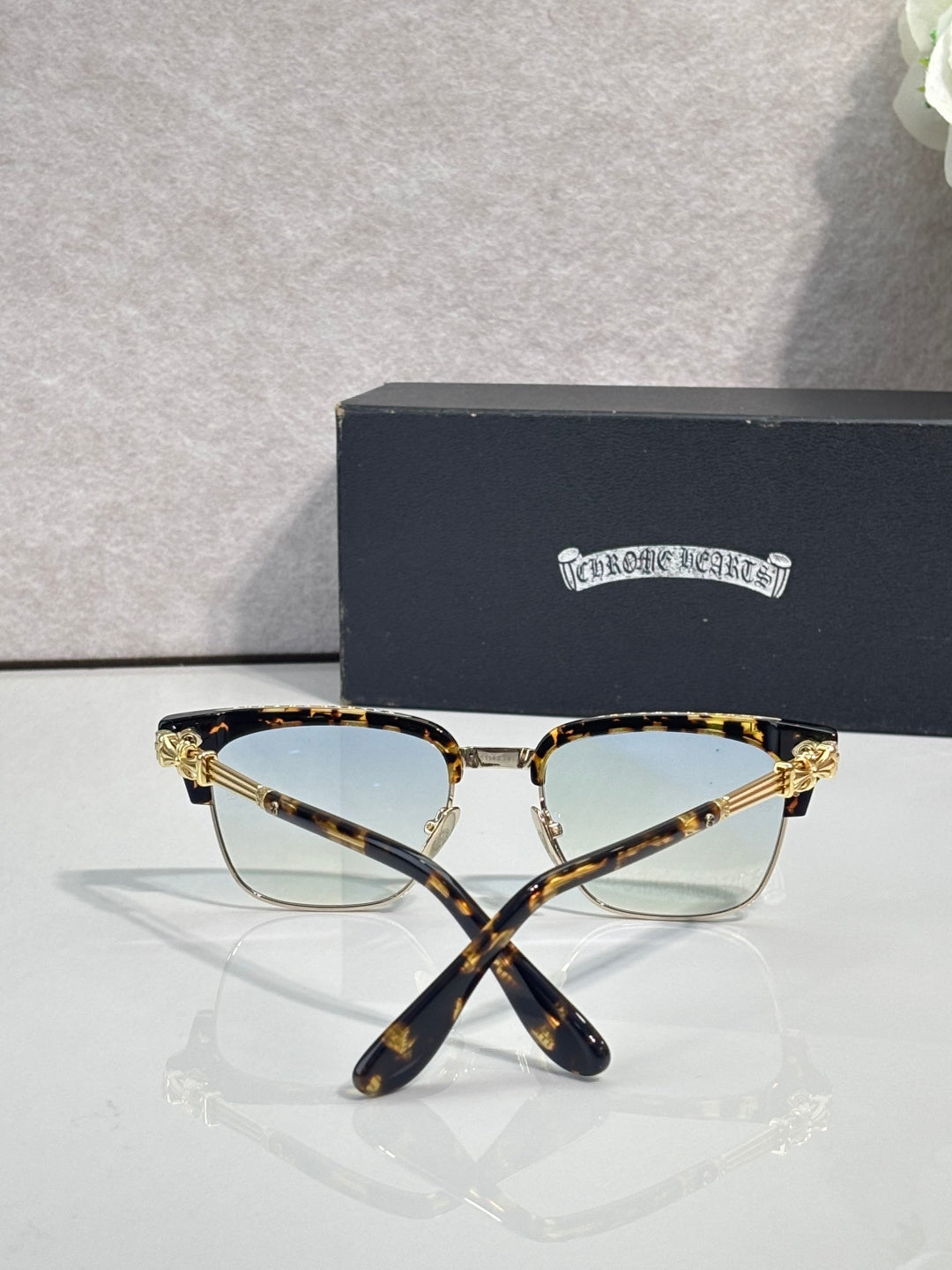 Cat-eye glasses with tortoise frame, gold arms, and clear lenses