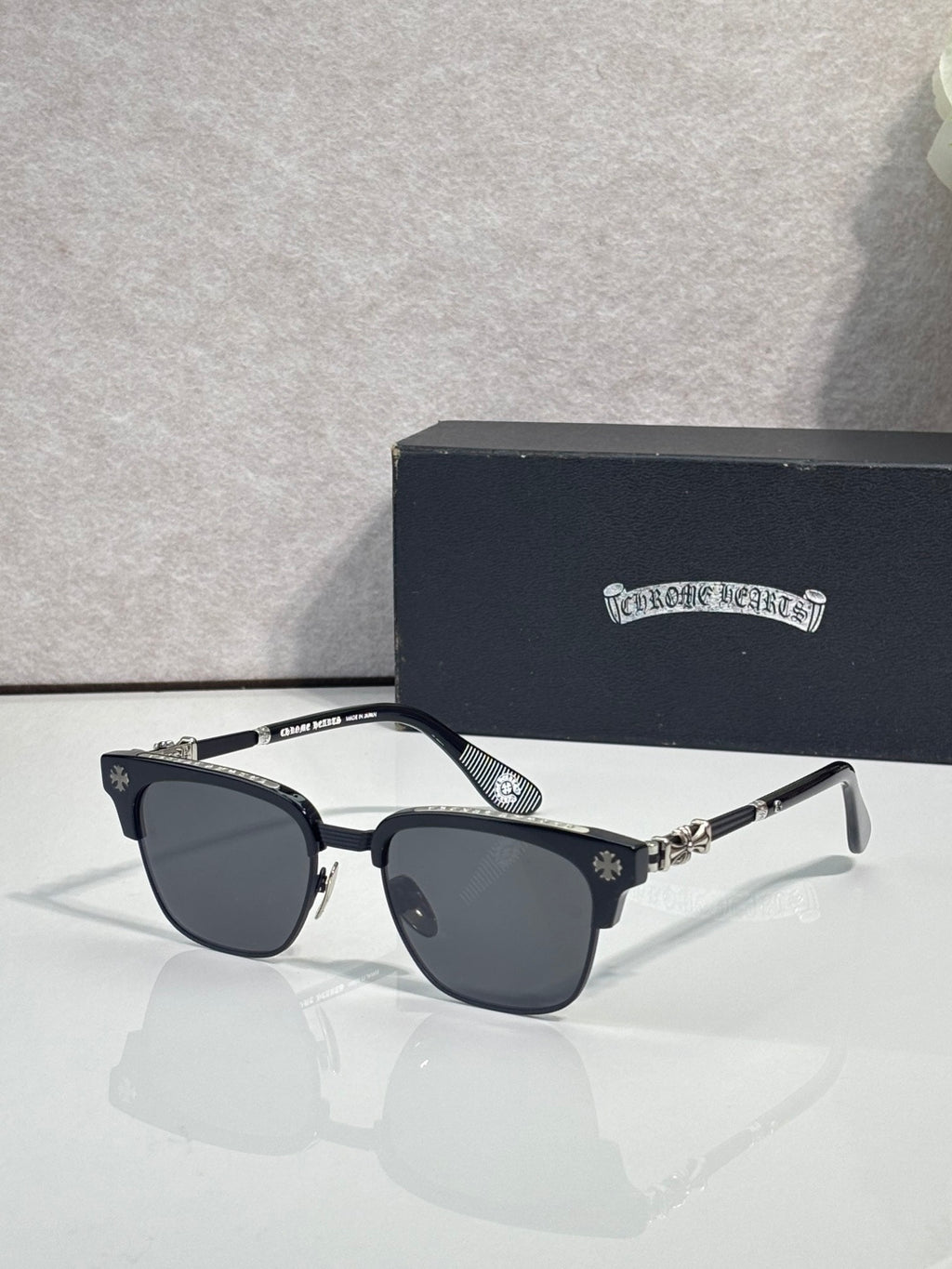 Cat-eye glasses with black frame, gold arms, and dark-tinted lenses