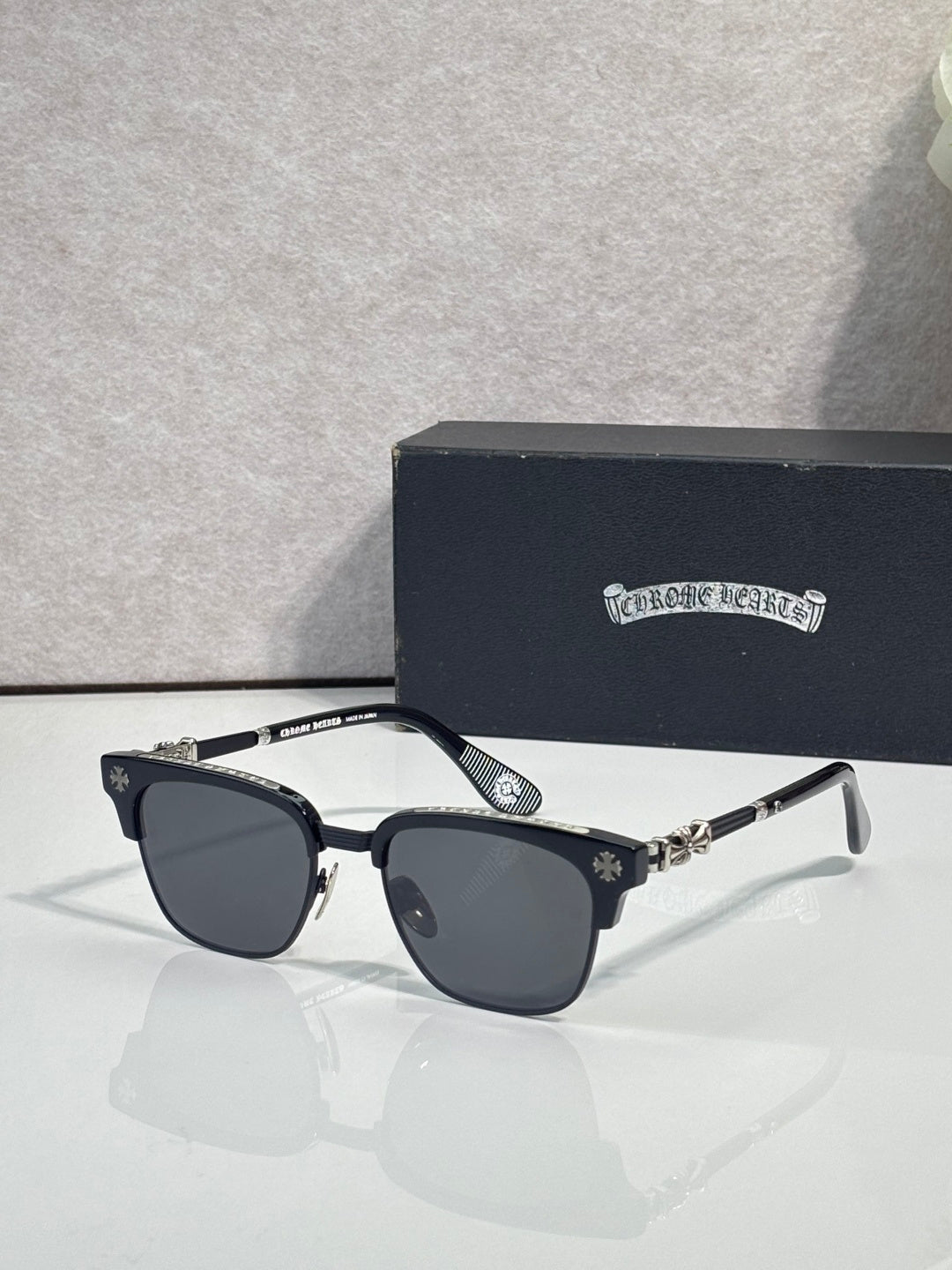 Cat-eye glasses with black frame, gold arms, and dark-tinted lenses