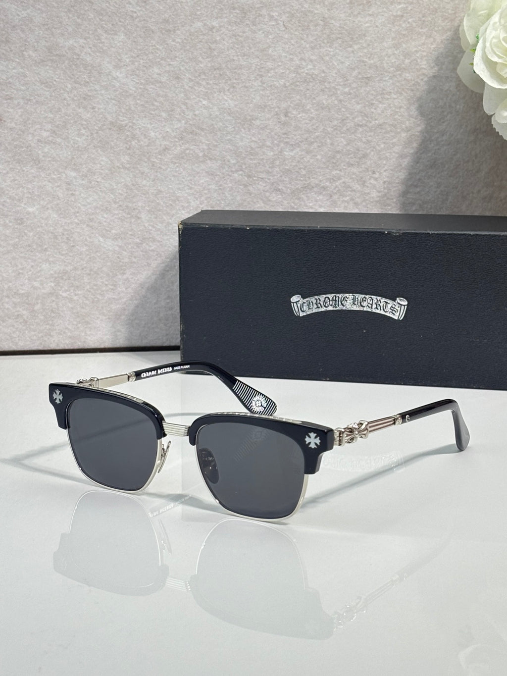 Cat-eye glasses with dark frame, gold arms, and dark-tinted lenses