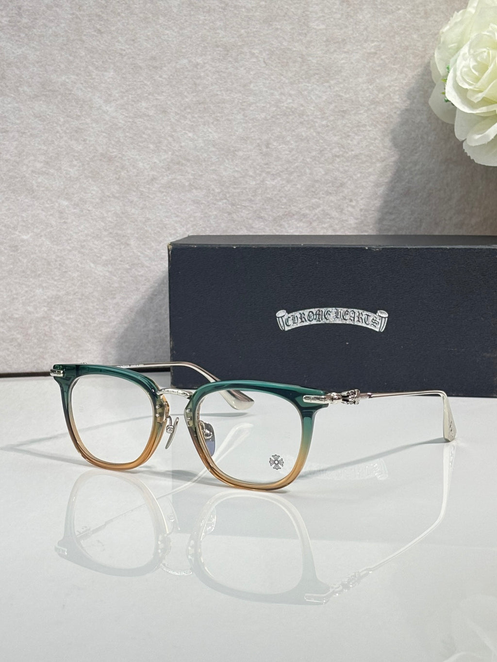Chrome eyeglasses with green frames and gold temples, clear lenses