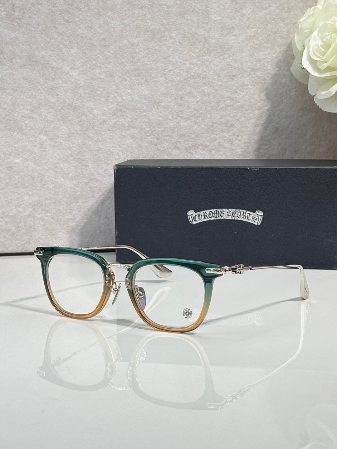 Chrome eyeglasses with green frames and gold temples, clear lenses