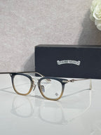 Chrome eyeglasses with dark blue frames and gold metal bridge, clear lenses