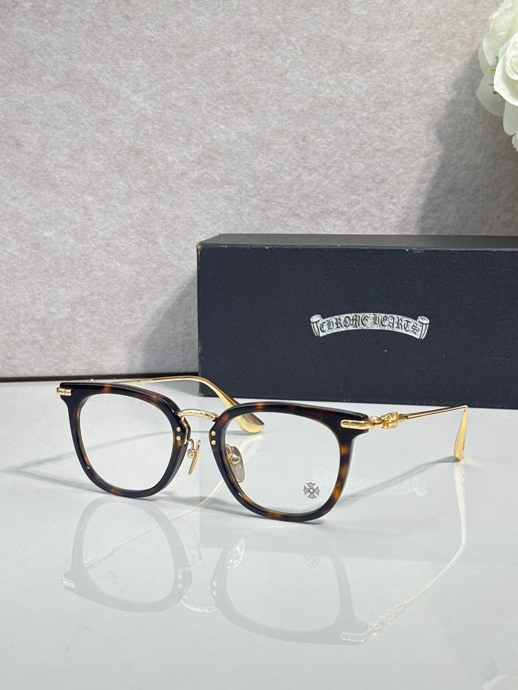 Chrome eyeglasses with dark blue front and gold accents, clear lenses