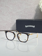 Chrome eyeglasses with dark blue front and gold accents, clear lenses