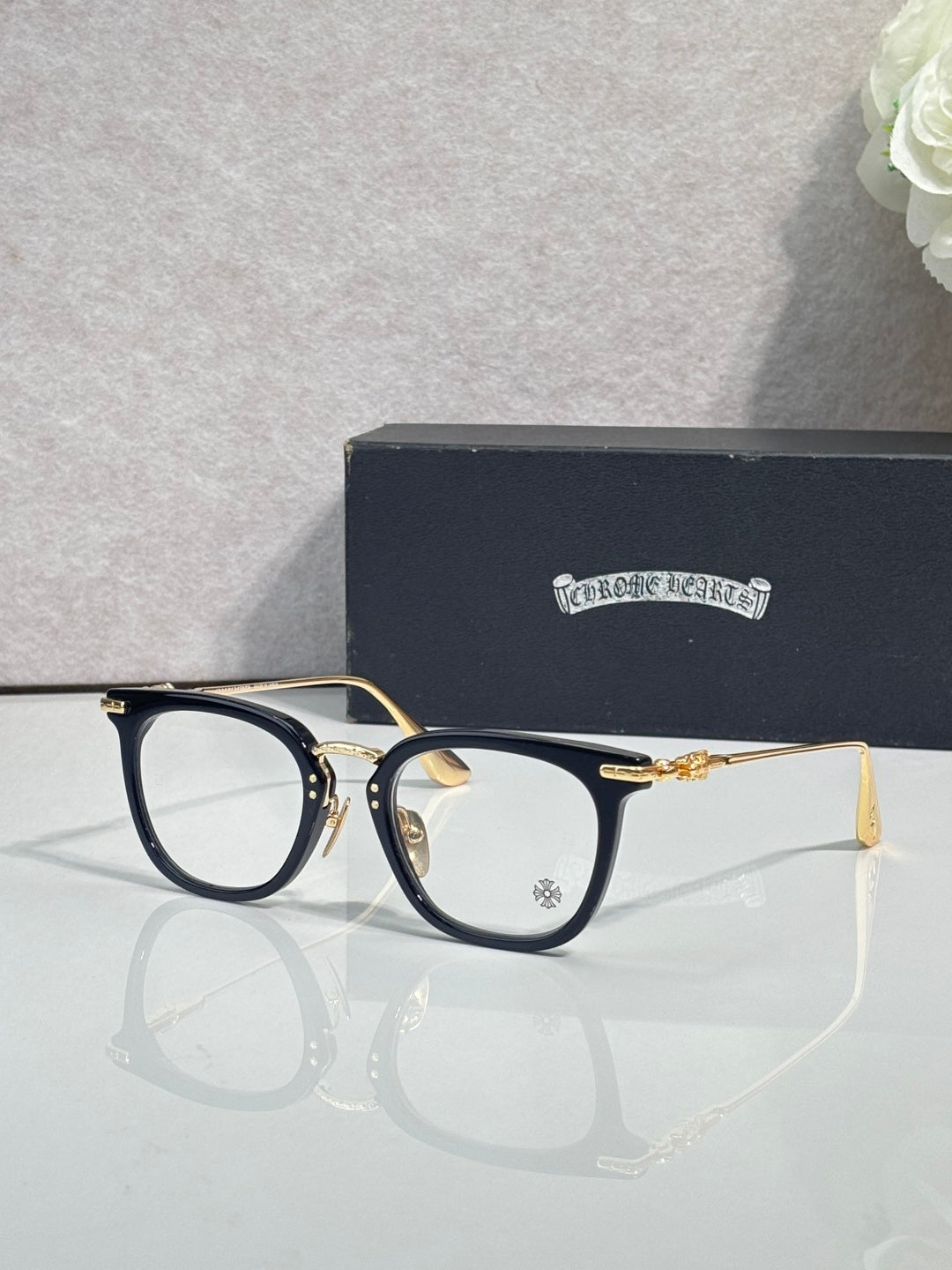 Chrome eyeglasses with navy frames, gold temples, and clear lenses