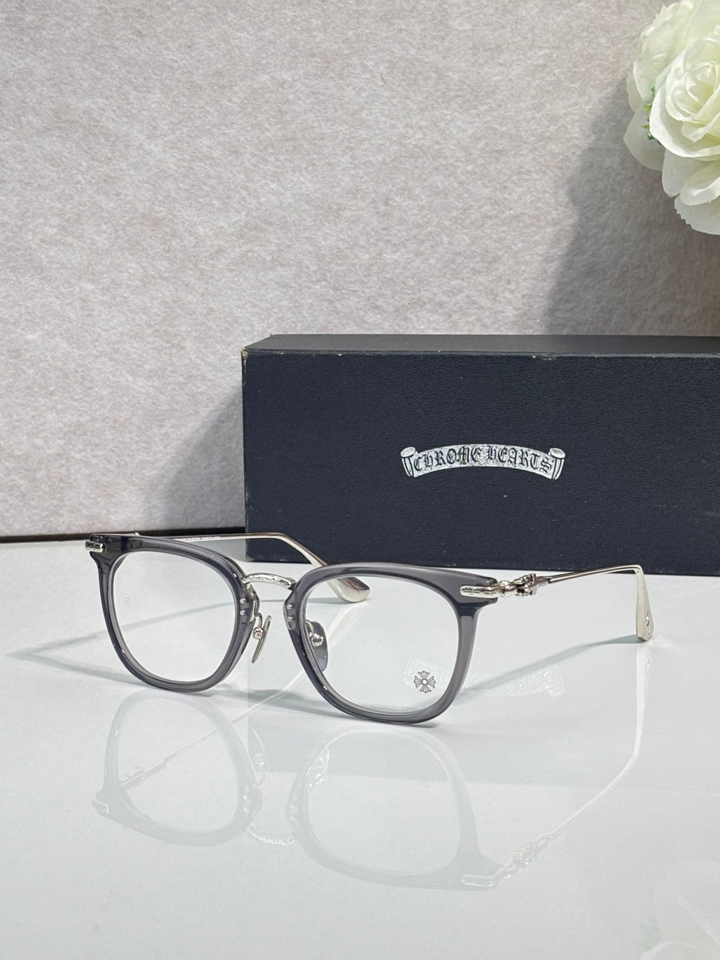 Chrome eyeglasses with dark blue round frames and clear lenses