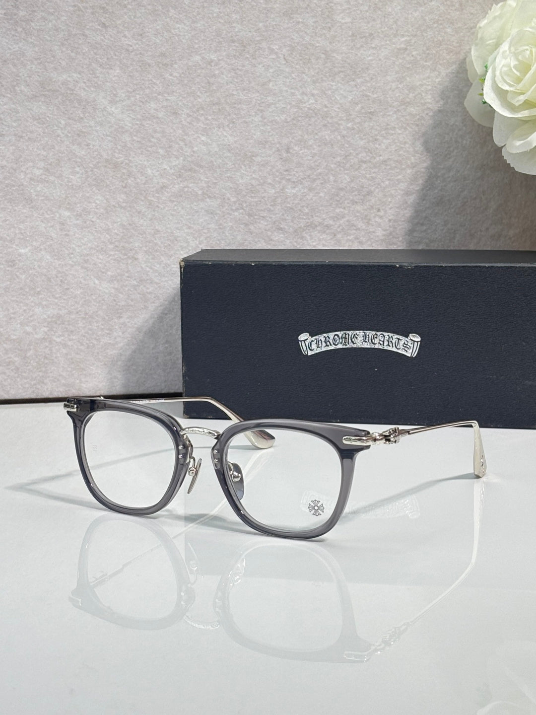 Chrome eyeglasses with dark blue round frames and clear lenses