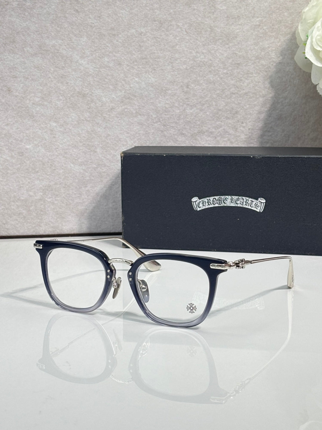 Chrome eyeglasses with dark blue frames, silver arms, and clear lenses
