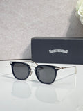 Chrome sunglasses with dark navy frames, gold-tone hinges, and tinted lenses