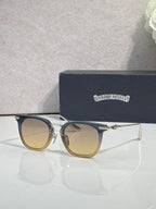 Chrome sunglasses with gold-beige frames, tinted lenses, and gold-tone temple details