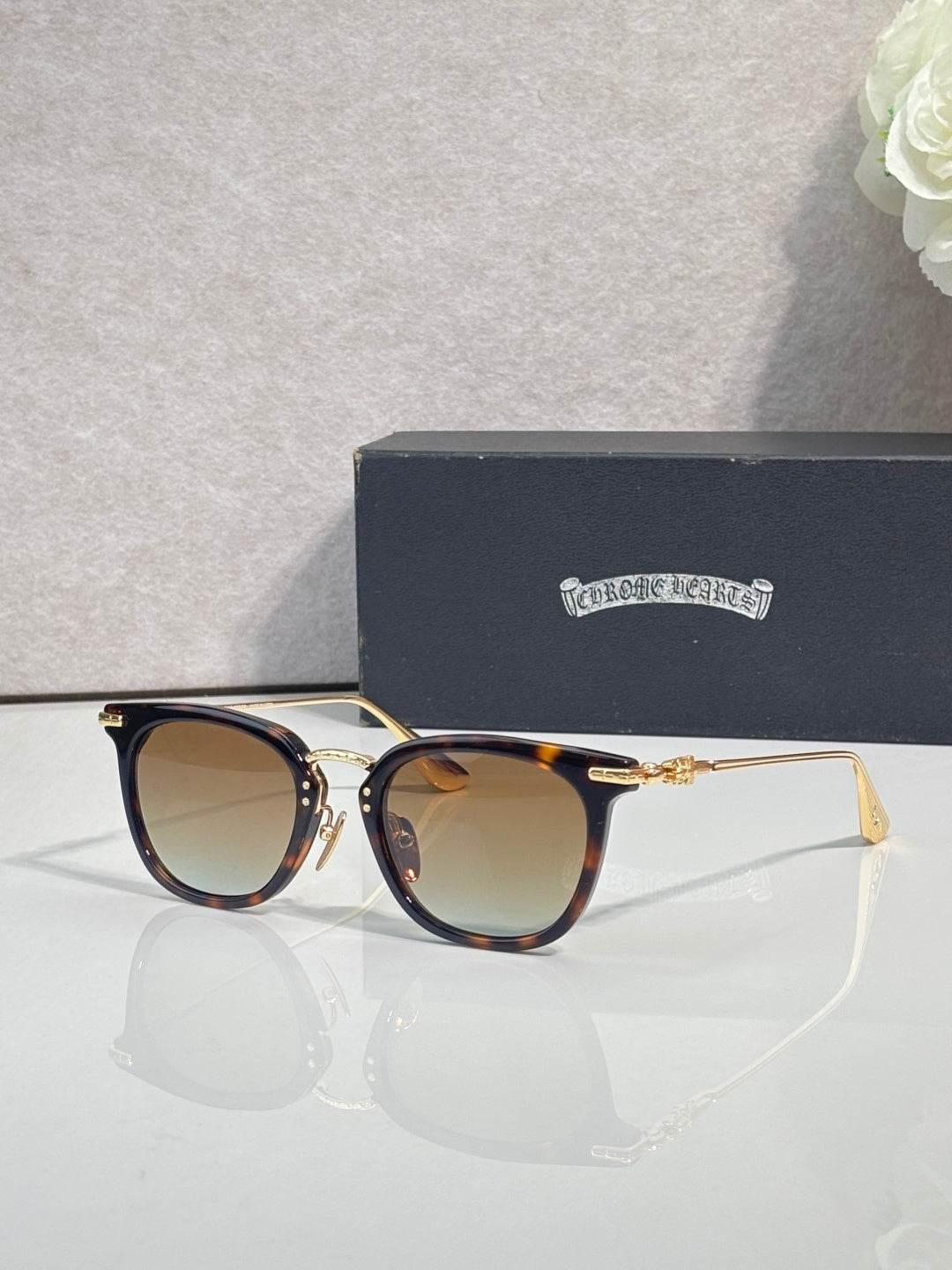 Chrome sunglasses with brown tortoise frames, gold-tone hinges, and tinted lenses