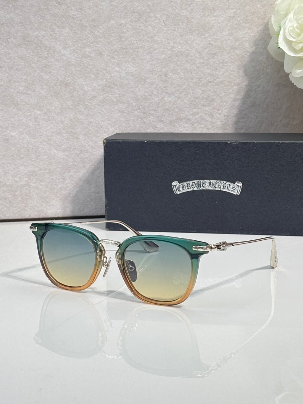 Chrome sunglasses with green-tinted frames, gold-tone accents, and tinted lenses