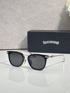Chrome sunglasses with dark navy cat-eye frames and gold-tone temple tips