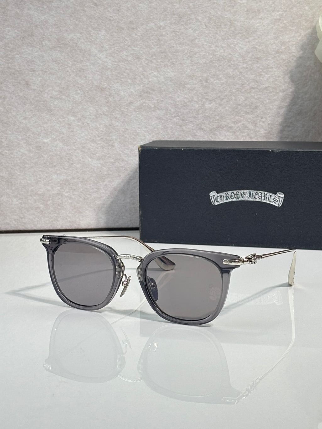 Chrome sunglasses with dark navy frames, silver-tone arms, and tinted lenses