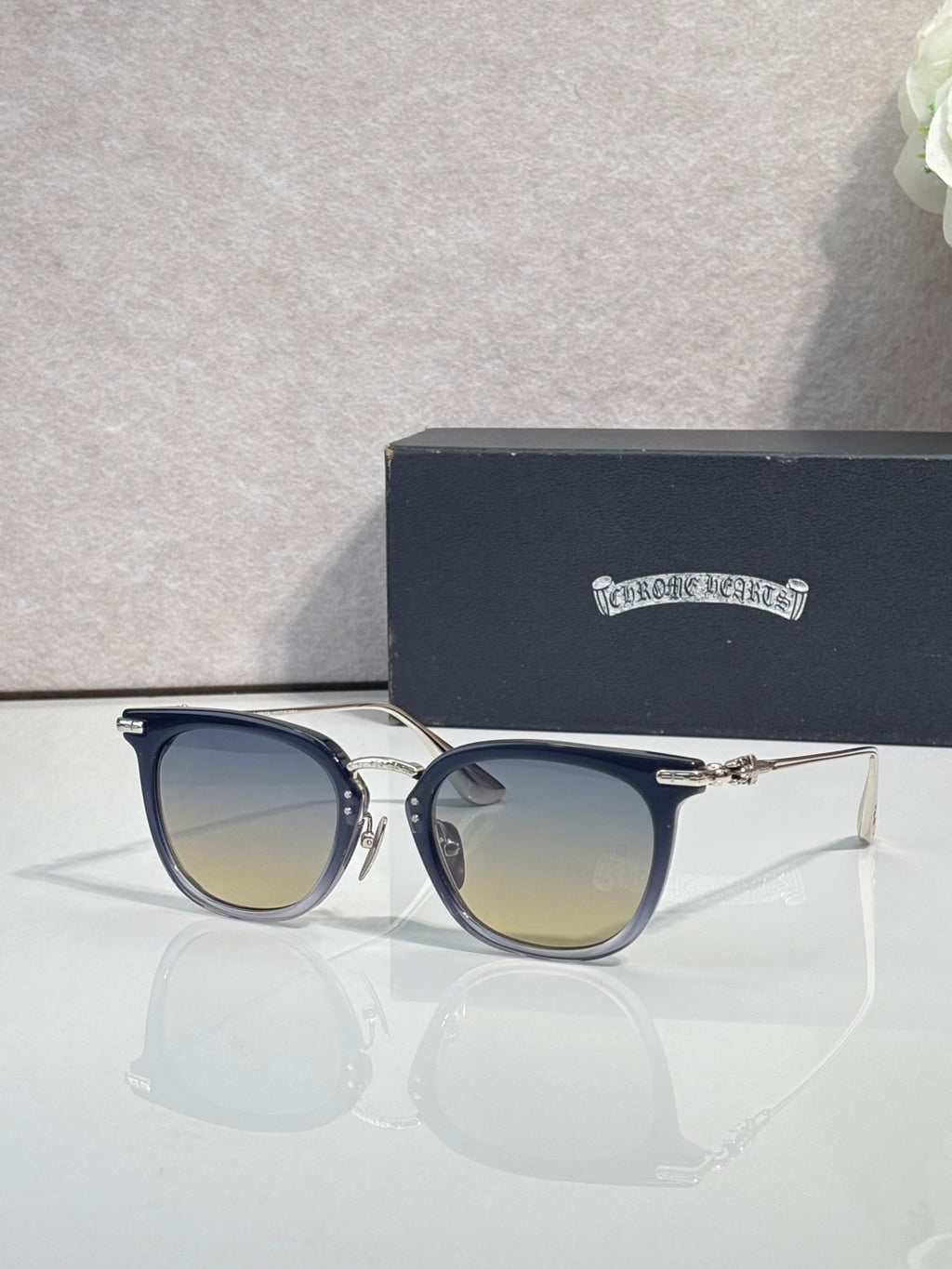 Chrome sunglasses with dark navy frames, gold-tone details, and tinted lenses