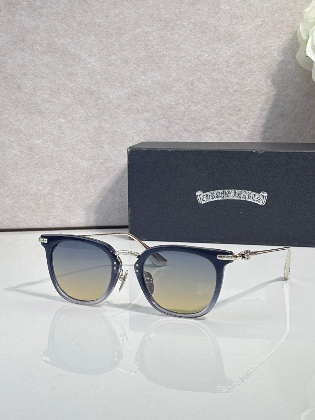Chrome sunglasses with dark navy frames, gold-tone details, and tinted lenses