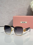 Gold-tone sunglasses with dark lenses and green temples, angular oversized frame