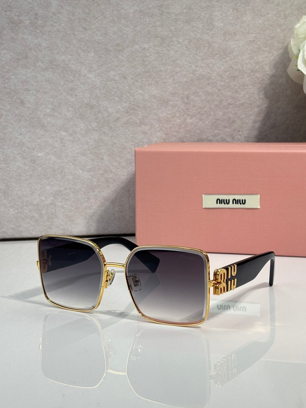 Gold square sunglasses with dark gradient lenses and patterned gold temple details