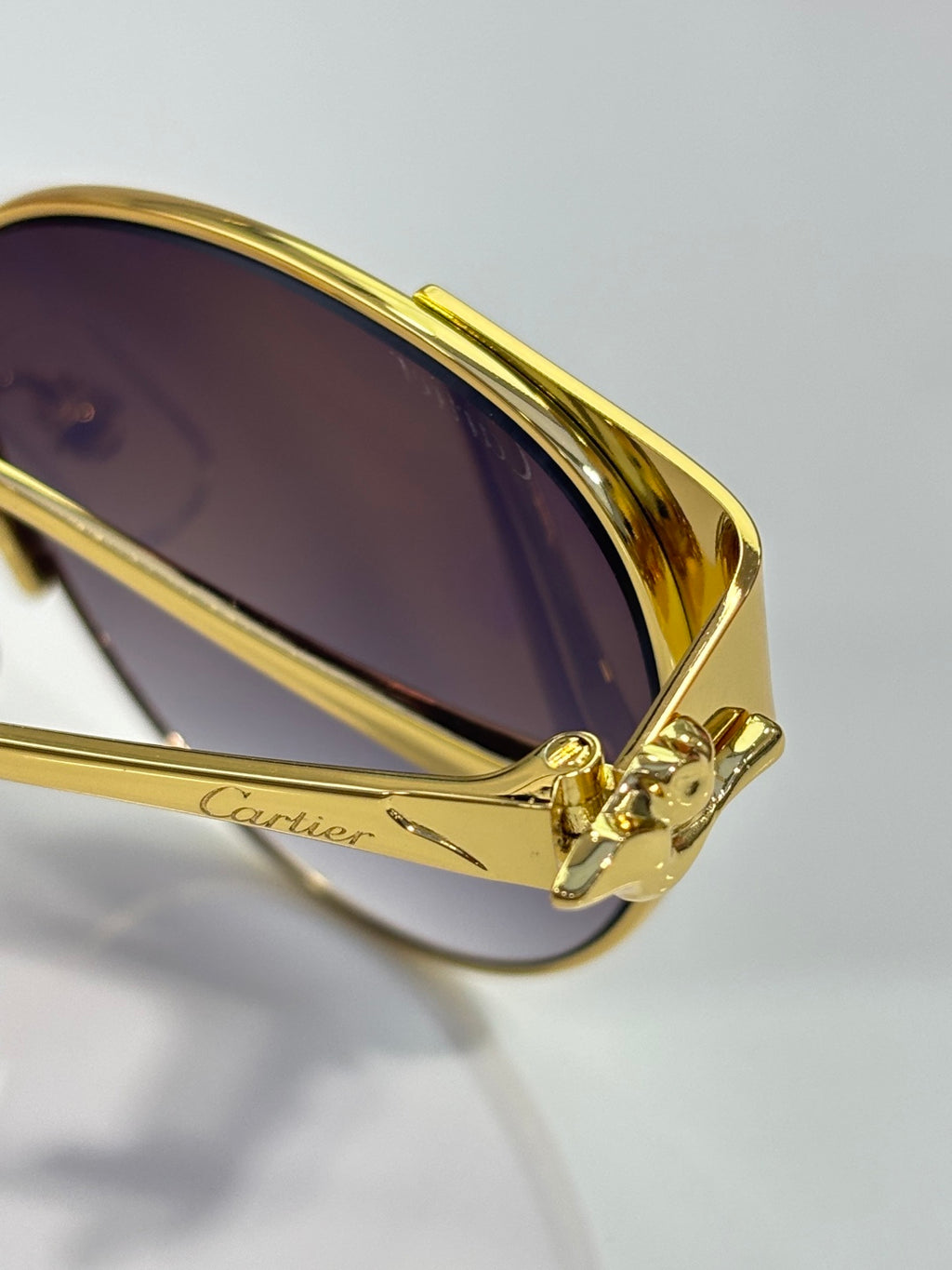 Cartier sunglasses temple close-up in gold with Cartier engraving