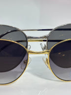 Cartier glasses close-up: round dark-tinted lenses with gold and silver-tone frames
