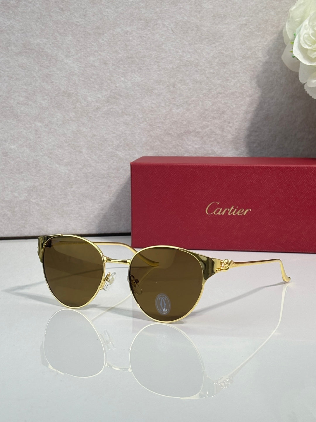 Cartier glasses with gold-tone round frames and olive tinted lenses