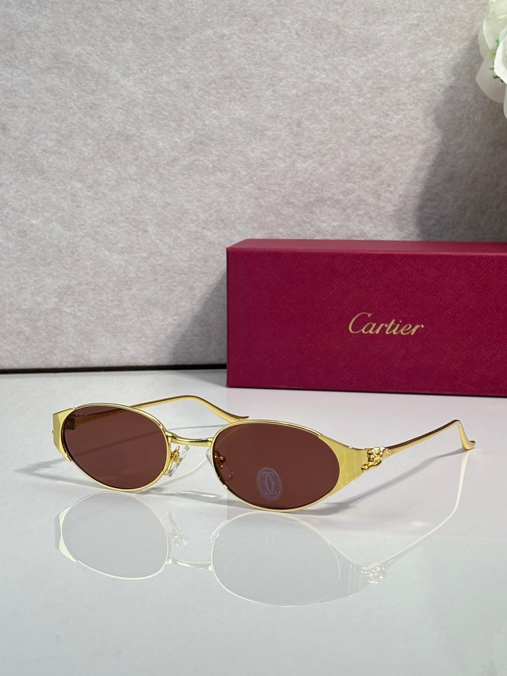 Gold eyeglasses with round brown-tinted lenses and slim metal frame