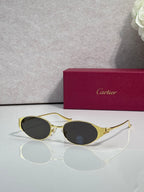 Cartier sunglasses with gold frames and dark oval lenses