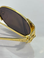 Cartier sunglasses close-up with gold frame and dark oval lens