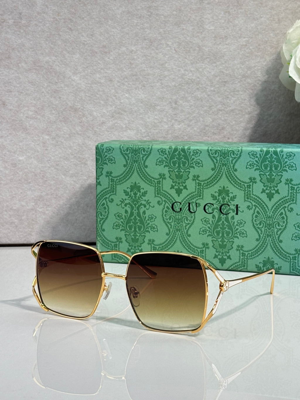 Square sunglasses with gold-tone frames and brown gradient lenses