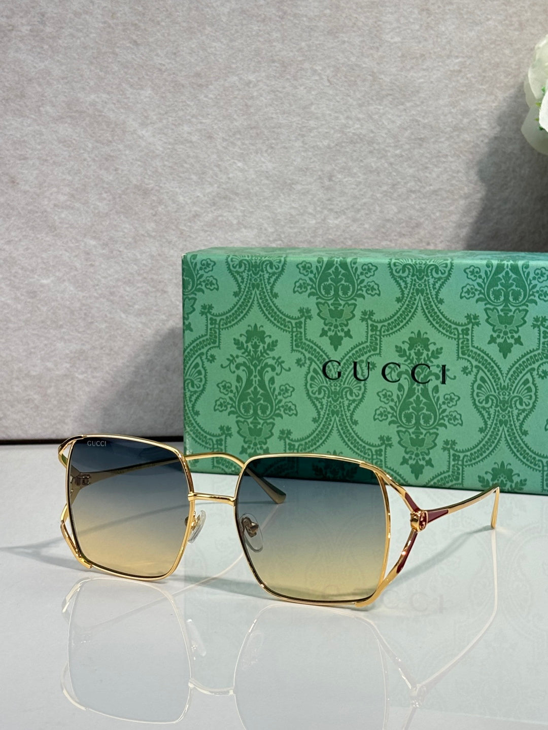 Square sunglasses with gold-tone frames and smoky gradient lenses