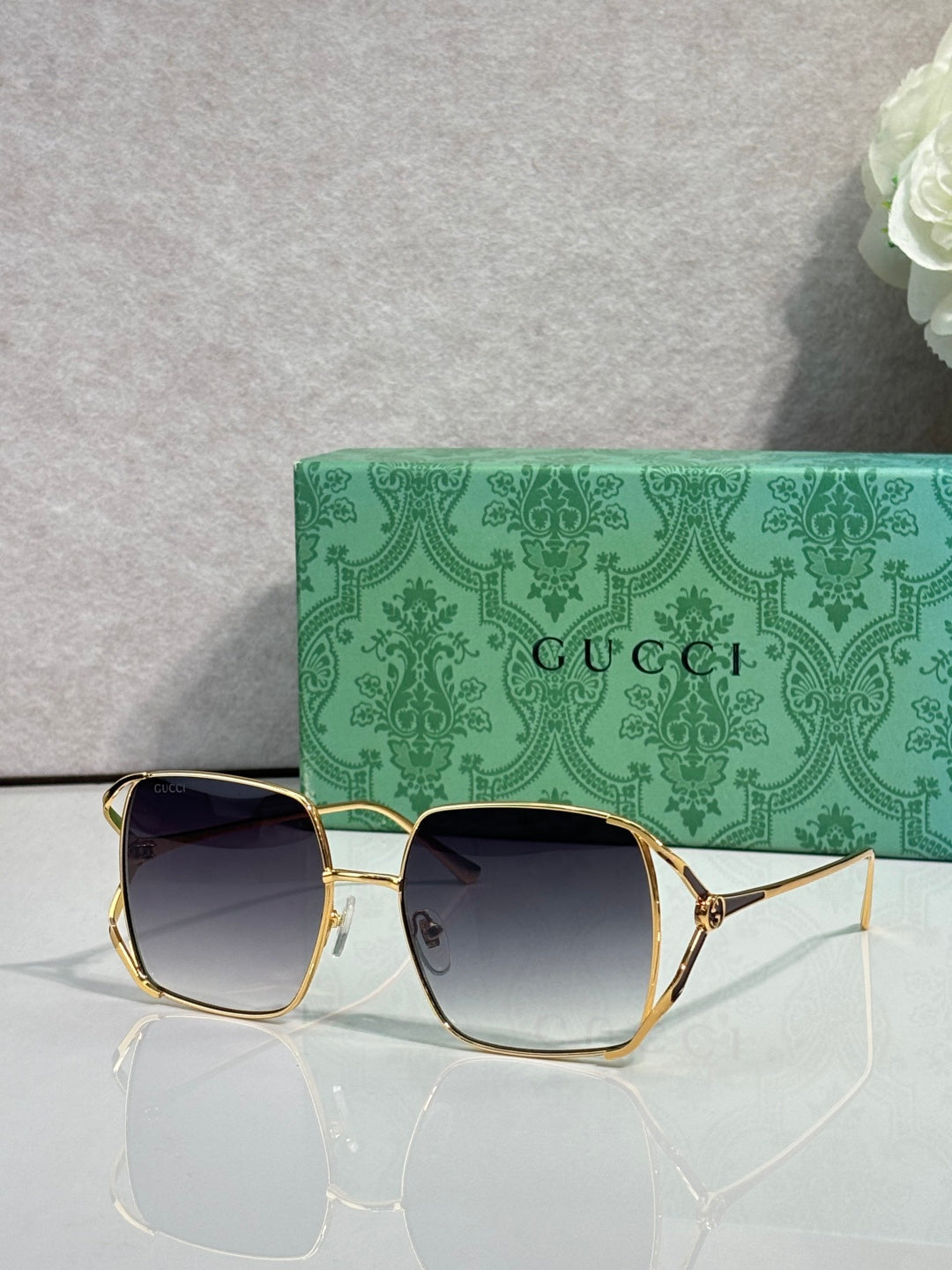 Gucci glasses with gold-tone square frames and dark gradient lenses