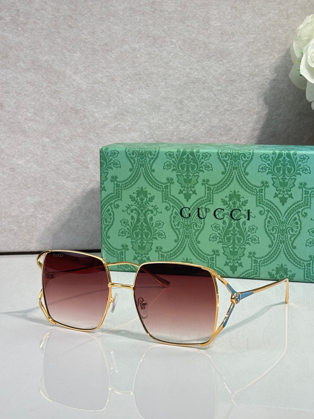 Square sunglasses with gold-tone frames and rosy pink gradient lenses