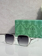 Square sunglasses with gold-tone frames and dark purple gradient lenses