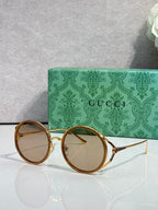 Round eyeglasses with gold metal frames and clear-to-light tinted round lenses