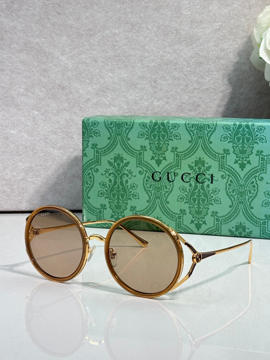 Round eyeglasses with gold metal frames and clear-to-light tinted round lenses
